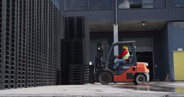 Worker operates a forklift at an industrial site, with copy space. Safety gear is visible, emphasizing the importance of workplace safety.