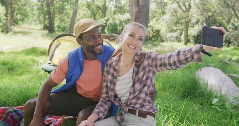 Diverse Couple Enjoying Camping Trip Taking Selfie in Forest