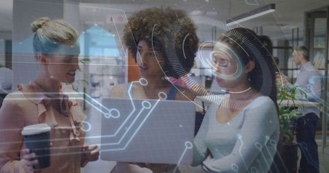 Diverse women collaborating in modern high-tech office with digital interface