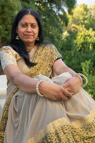 Indian woman in traditional sari relaxing in garden setting