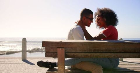 Young Biracial Couple Embracing on Sunny Beach Promenade