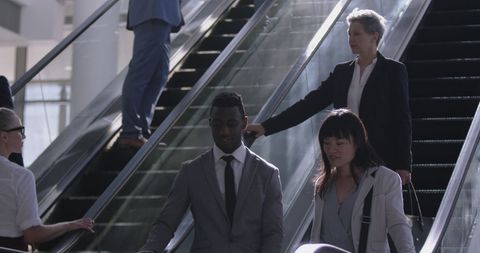Professionals Commuting on Office Escalator Under Bright Light