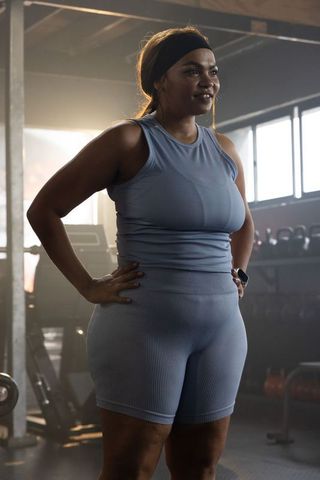 Confident african american woman working out in warehouse gym wearing blue activewear