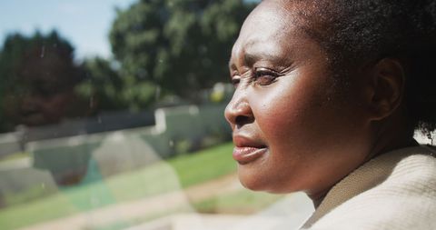 Reflective Senior Woman Gazing Out Window Thoughtfully