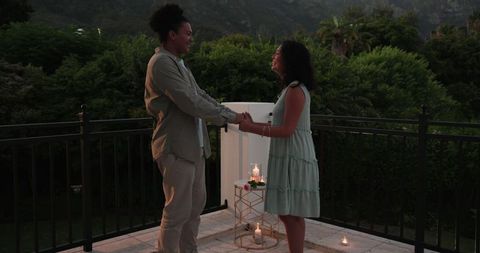 Couple's romantic engagement proposal on scenic balcony