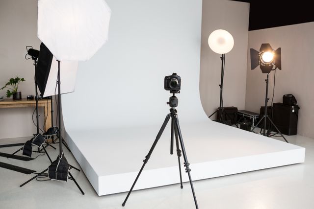 Empty photo studio with lighting equipment and digital camera