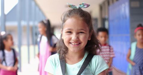 Smiling Girl with Backpack in Busy School Hallway - Download Free Stock Images Pikwizard.com