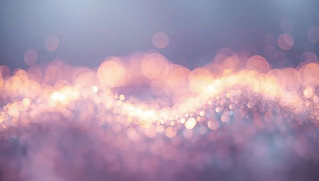Pastel Bokeh Wave of Glittering Lights and Soft Golden Sparkle on Lavender Surface