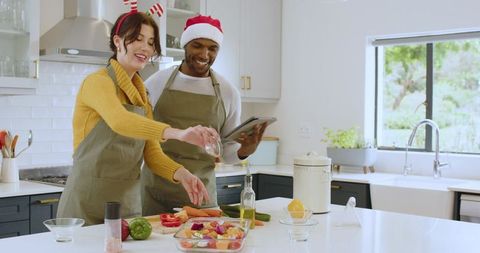 Diverse couple preparing festive holiday meal in modern kitchen