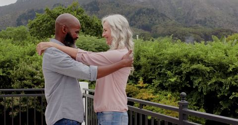 Happy Mature Couple Embracing Outdoors on Balcony