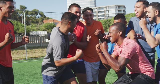 Diverse male football players training and celebrating together on outdoor pitch - Download Free Stock Photos Pikwizard.com