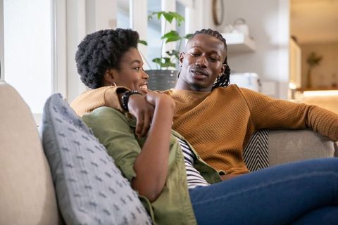 African American Couple Relaxing and Laughing in Cozy Living Room