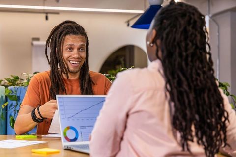 African American coworkers discussing data and charts in casual office collaboration