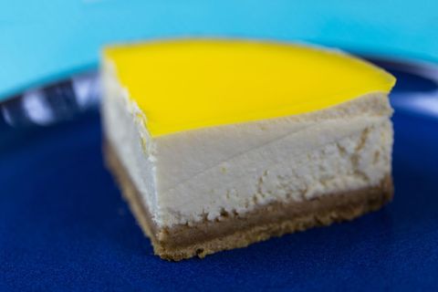 Refreshing lemon-topped cheesecake slice on blue plate