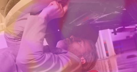 Senior mechanic performing vehicle maintenance in garage