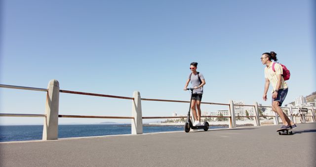 Two Friends Enjoying Ride on Electric Scooter and Skateboard by Seaside - Download Free Stock Images Pikwizard.com