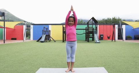 Child Practicing Yoga in Colorful School Playground
