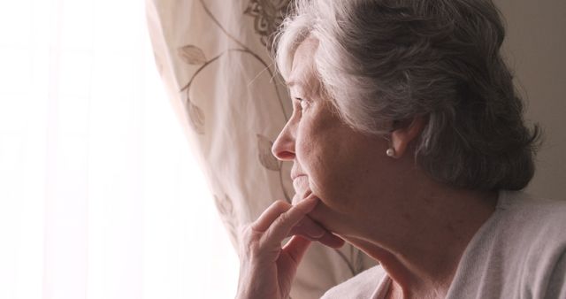 Contemplative Senior Woman Looking Through Window - Download Free Stock Images Pikwizard.com