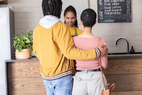 African american couple ordering coffee at cozy cafe counter with friendly barista