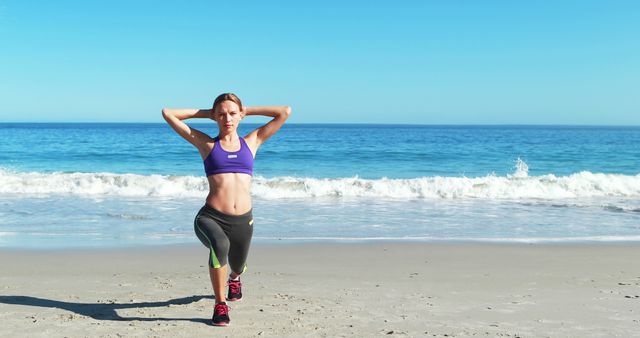 A woman is performing lunges on the beach, wearing fitness attire, with the ocean and bright blue sky in the background. This image can be used for promoting health and fitness programs, workout plans, beach fitness activities, healthy living blogs, and sportswear advertisements.