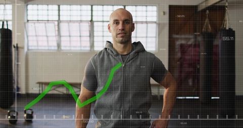 Personal trainer tracking workout progress with green performance chart overlay in gym