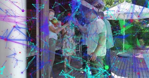 Friends clinking glasses on backyard deck with neon network overlay celebrating summer