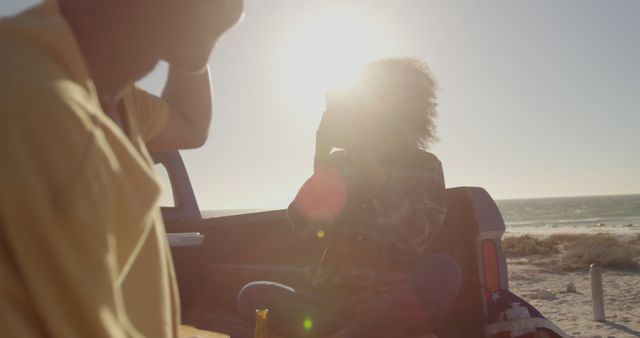 Young couple sitting on truck bed at beach during sunset - Download Free Stock Images Pikwizard.com