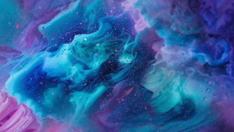 Swirling teal and cyan pigment plumes creating iridescent abstract nebula with microbubbles