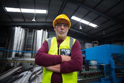 Senior Technician in Bottling Plant with Safety Gear at Work