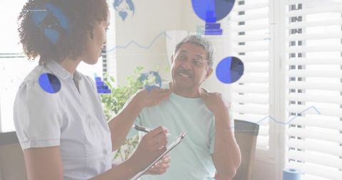 Home Caregiver Listening to Senior Man Reporting Shoulder Pain During Health Assessment