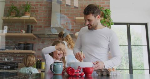 Father and Daughter Baking Together on Kitchen Island Mixing Bowl and Red Measuring Cups