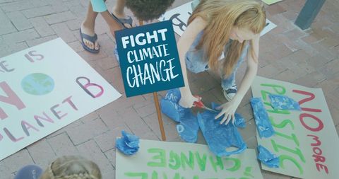 Children creating climate change protest banners outdoors
