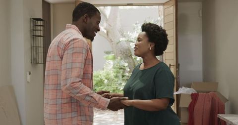 Happy african american couple unpacking in new home together