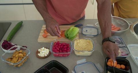 African american men preparing meal-prep chopping carrots organizing fresh vegetables