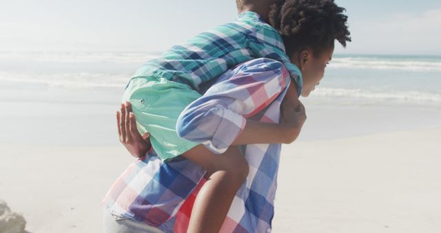 Mother Giving Playful Piggyback Ride to Her Son on Beach - Download Free Stock Images Pikwizard.com