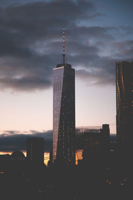 One World Trade Center at dusk represents a modern architectural landmark in New York City's skyline. The skyscraper stands tall against the evening sky, reflecting the transformation of light. This can be used in content emphasizing urban development, travel, or New York City attractions. Ideal for advertisements, blogs, or realty promotions focusing on iconic infrastructure or city life.