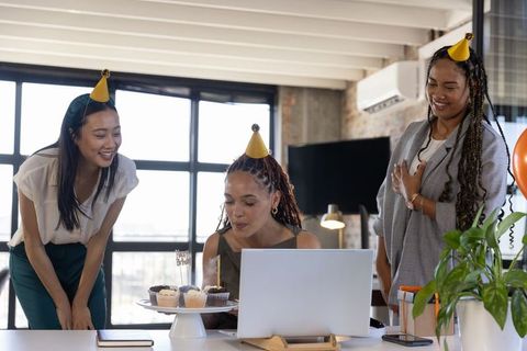 Diverse Female Coworkers Celebrating with Cupcakes at Modern Office