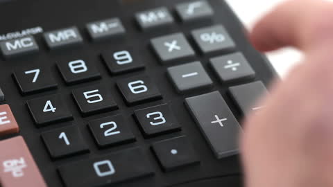 Close-up of Hand Using Calculator on White Background