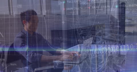 Asian Businessman Analyzing Stock Market Data with Laptop in Office