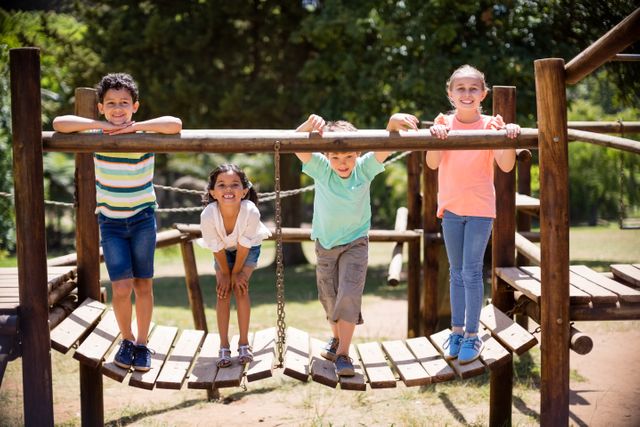 Portrait of kids standing and smiling on a playground ride in park