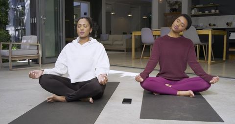 Diverse Women Meditating Outdoors on Terrace