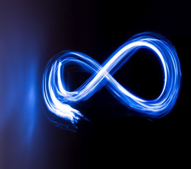 Glowing blue infinity symbol created with light painting technique on a black backdrop. Ideal for illustrating concepts of infinity, limitless possibilities, continuity, and futuristic themes. Suitable for use in digital art, technology presentations, sci-fi themed projects, or as an abstract background.