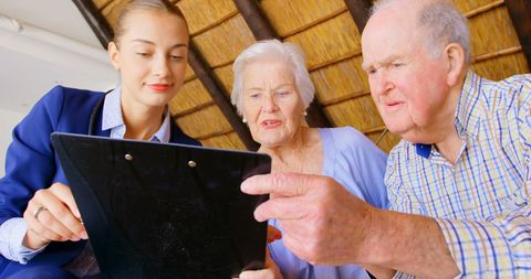 Senior Couple Consulting Patient Records with Doctor