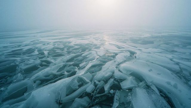 Mysterious frozen lake with fractured ice and misty haze