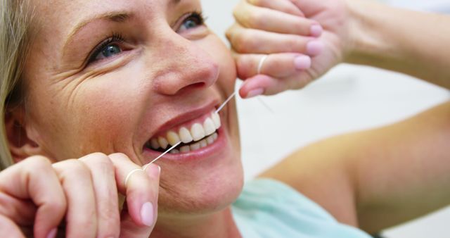 Smiling Woman Flossing Teeth for Dental Hygiene - Download Free Stock Images Pikwizard.com