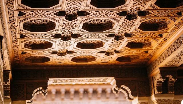 Ornate octagonal coffered wooden ceiling featuring carved rosettes and arabesque detail