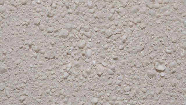 Cream pebble render texture closeup for exterior stucco and facade design