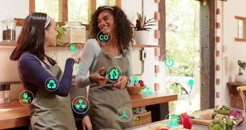 Smiling cooks collaborating in rustic kitchen with eco icons and fresh farm vegetables