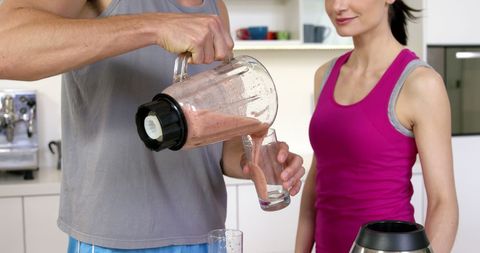 Couple Enjoying Fresh Smoothies Together in Modern Kitchen