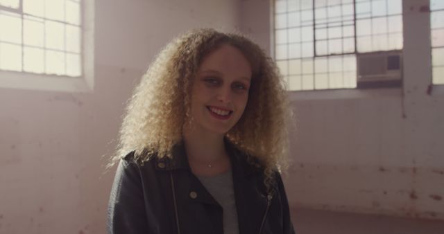 Smiling Young Woman with Curly Hair in Urban Loft - Download Free Stock Images Pikwizard.com